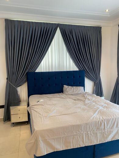 Curtains hung over a voile by KD Dream Space Designs