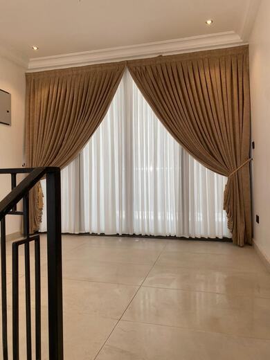 Curtains hung over a voile by KD Dream Space Designs
